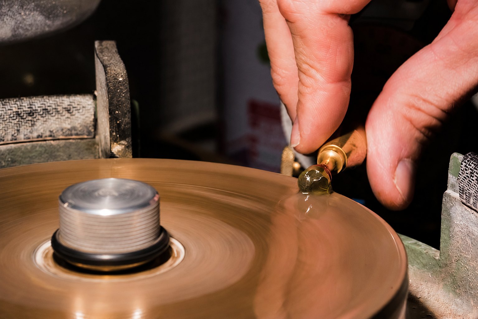 A stone held to the lap wheel by a dop stick, mid-polish